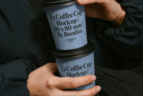 Person holding two coffee cup mockups with text Le Coffee Cup Mockup on blue background ideal for designers branding presentations templates assets.