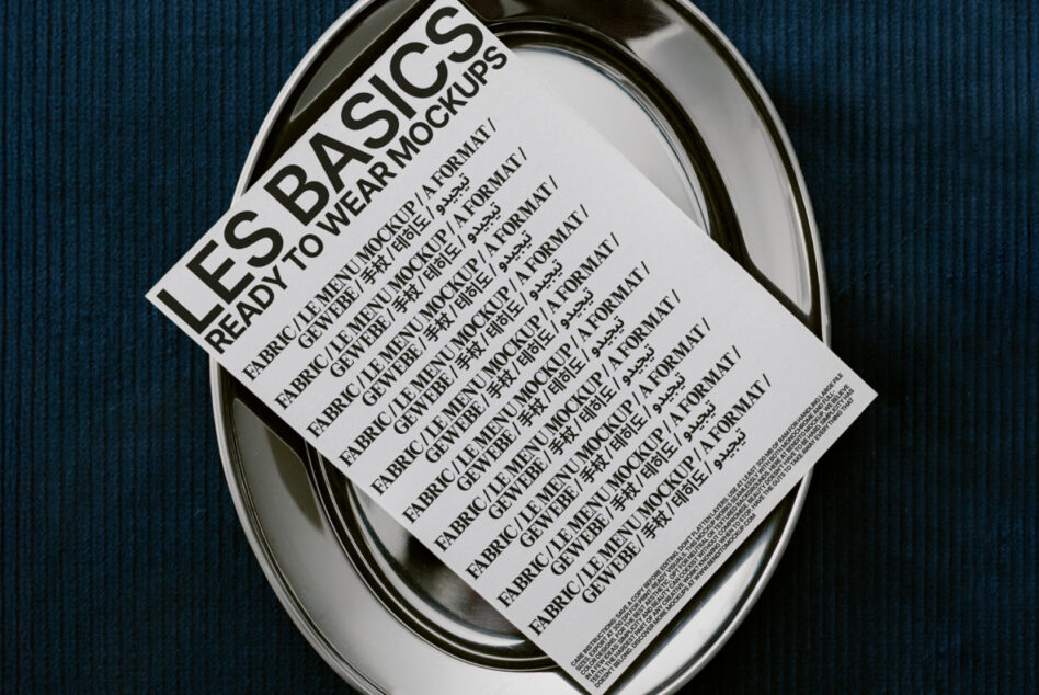 White ready to wear mockup sheet in oval metal tray on textured blue surface