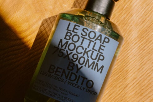 Soap bottle mockup 75x90mm on wooden surface for digital assets in design. Perfect for showcasing packaging graphics. Ideal for designers' templates.