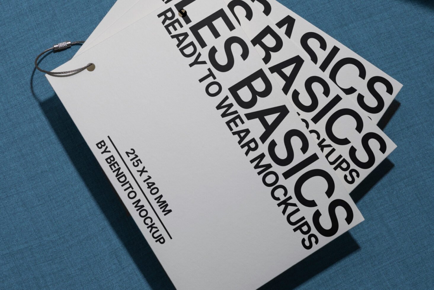 Minimalist mockup of a 215x140 mm tag set on a blue fabric surface. Ideal for showcasing branding designs. Keywords: Mockups, Design, Templates.
