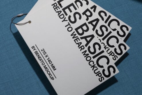 White hang tag mockup angled on blue fabric background