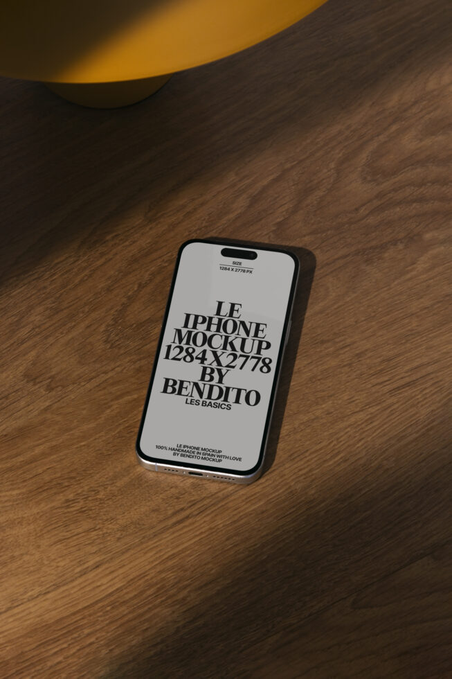 iPhone mockup on wooden surface with orange lamp shadow. Mockup dimensions 1284x2778 px. Ideal for graphic designers and UI presentations.