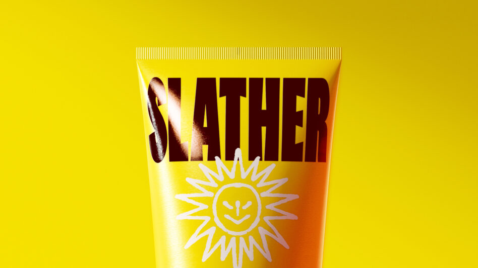Sunscreen tube close up showing bold slather text on yellow