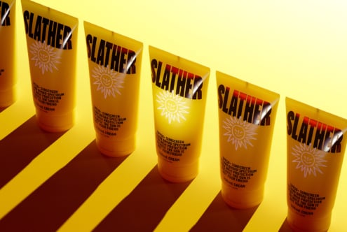 Sunscreen product mockup featuring bold packaging design in yellow tones. Ideal for designers focused on branding and identity development.