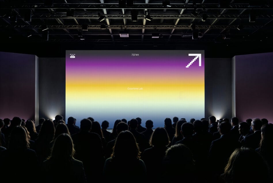 Crowd viewing vibrant gradient projection from purple through yellow to blue