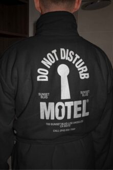 Black windbreaker back view with large white keyhole motel graphic design
