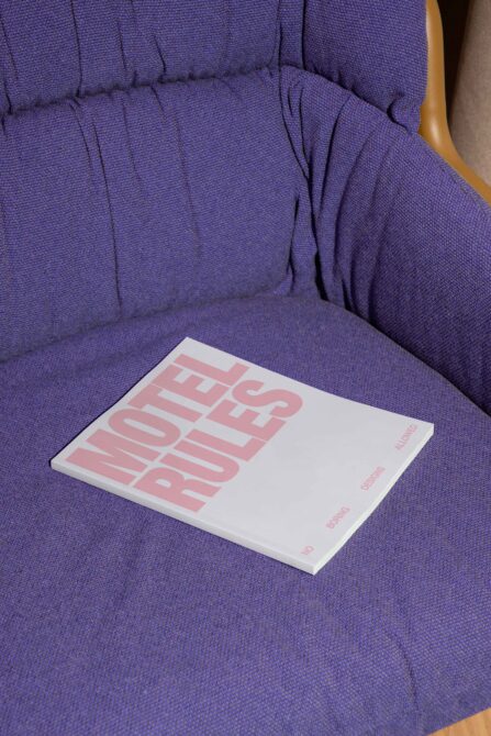 White magazine mockup with pink typography on purple fabric chair seat