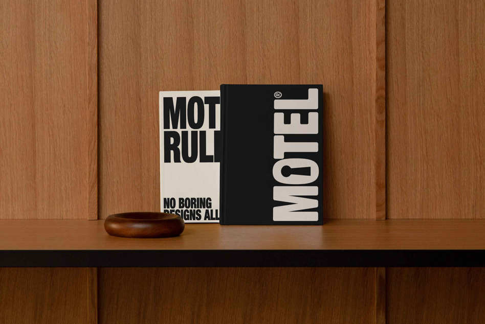 Square hardcover book mockup with black cover on wood shelf with bowl