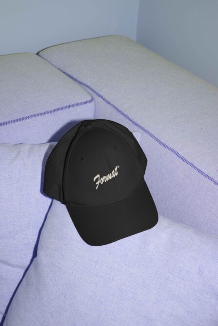 Black baseball cap with Format script logo on lavender fabric background