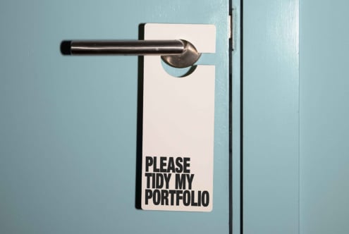 Door hanger mockup on a turquoise door with black text reading Please Tidy My Portfolio keyword design template graphic editable PSD download.