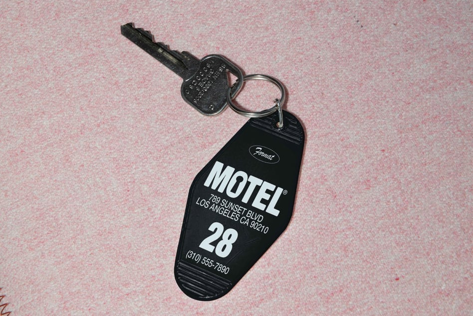 Vintage motel keychain mockup with room key on textured pink surface ideal for retro designs branding hotel decor templates SEO graphic design.