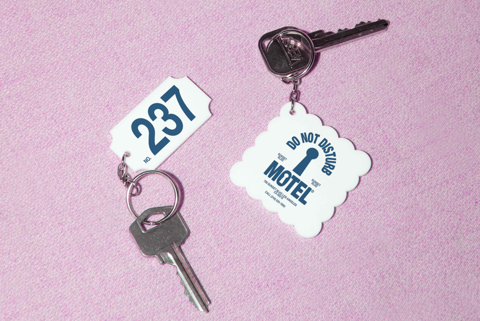 Vintage motel key tags with room number 237 on pink textured background