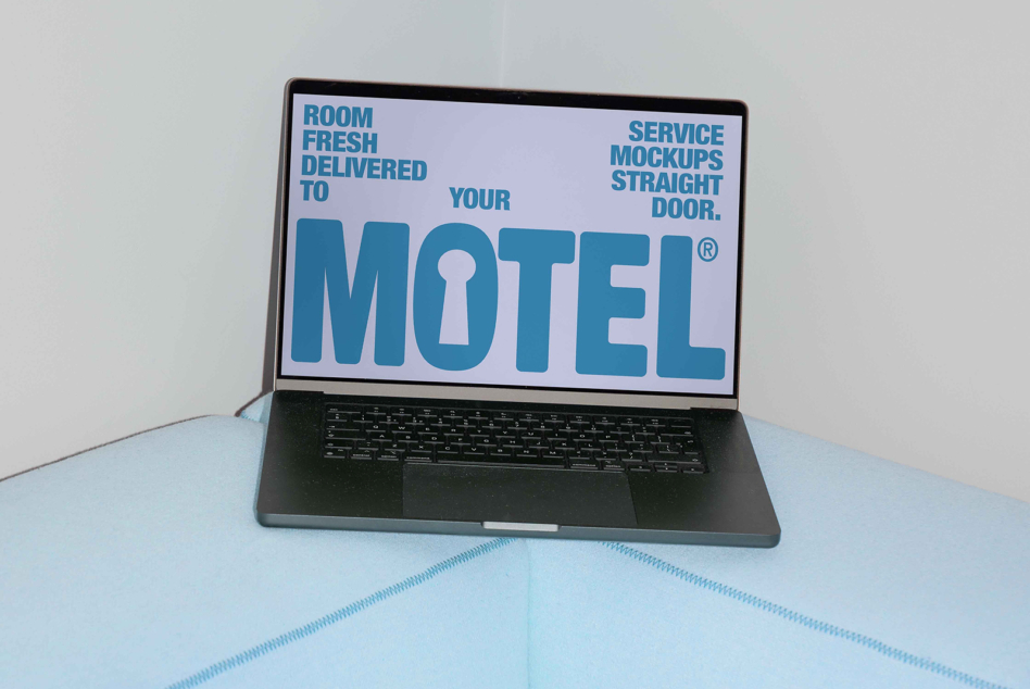Laptop on light blue cushion with teal MOTEL text on lavender display