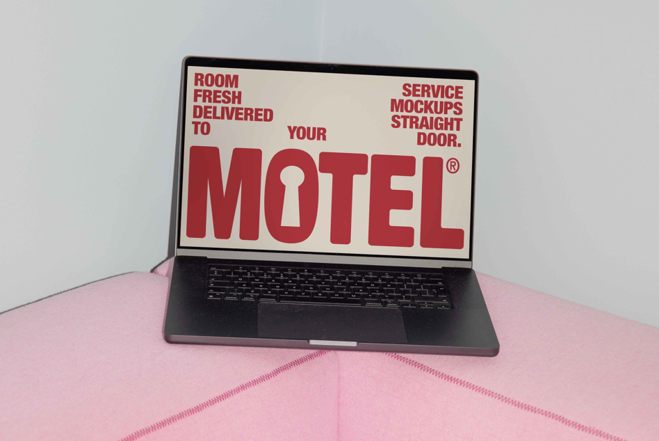 Laptop on pink surface showing red MOTEL vintage sign on screen