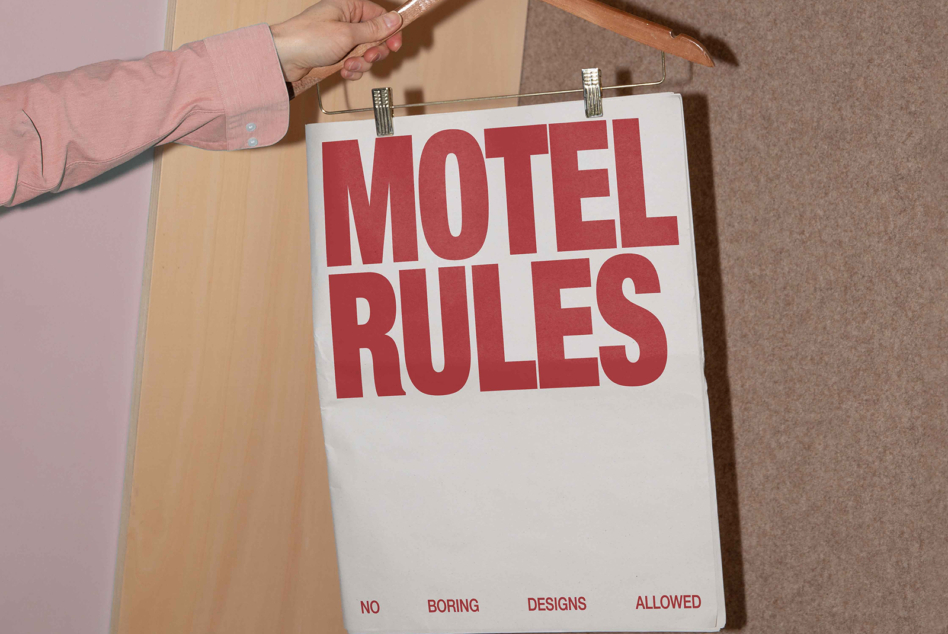 Red Motel Rules sign clipped to wooden hanger with no boring designs allowed subtext