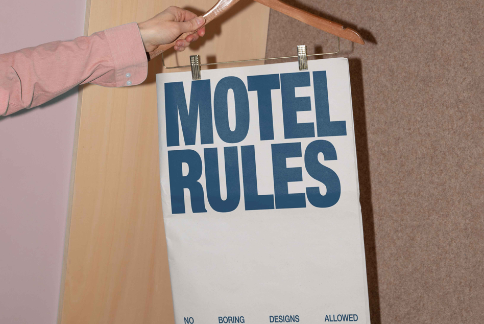 Blue Motel Rules sign clipped to wooden hanger with no boring designs allowed subtext