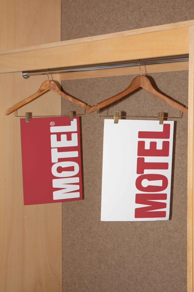 Posters with red text 'Motel' on hangers in a wooden closet mockup. Perfect for designers seeking templates and typography graphics for projects.