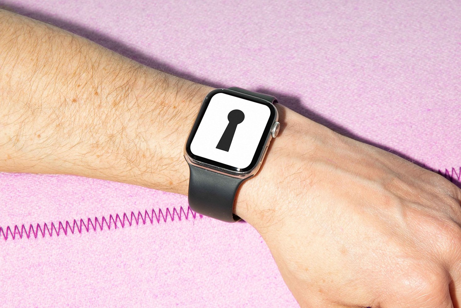 Smartwatch lock screen display on wrist with black band keyhole icon on watch face pink background wearable mockup digital asset for designers