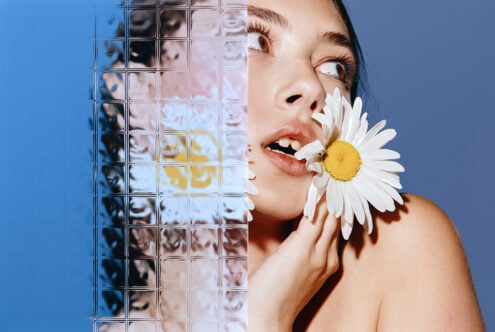 Portrait of a person with a daisy, glass texture overlay, creative design asset for designers, vibrant colors, ideal for graphic projects, mockups, templates.