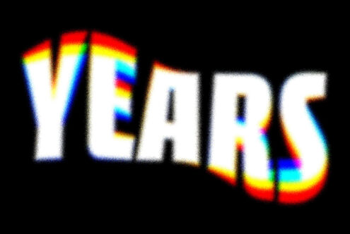 Bold rainbow chromatic blur text effect reading YEAR with 3D styling