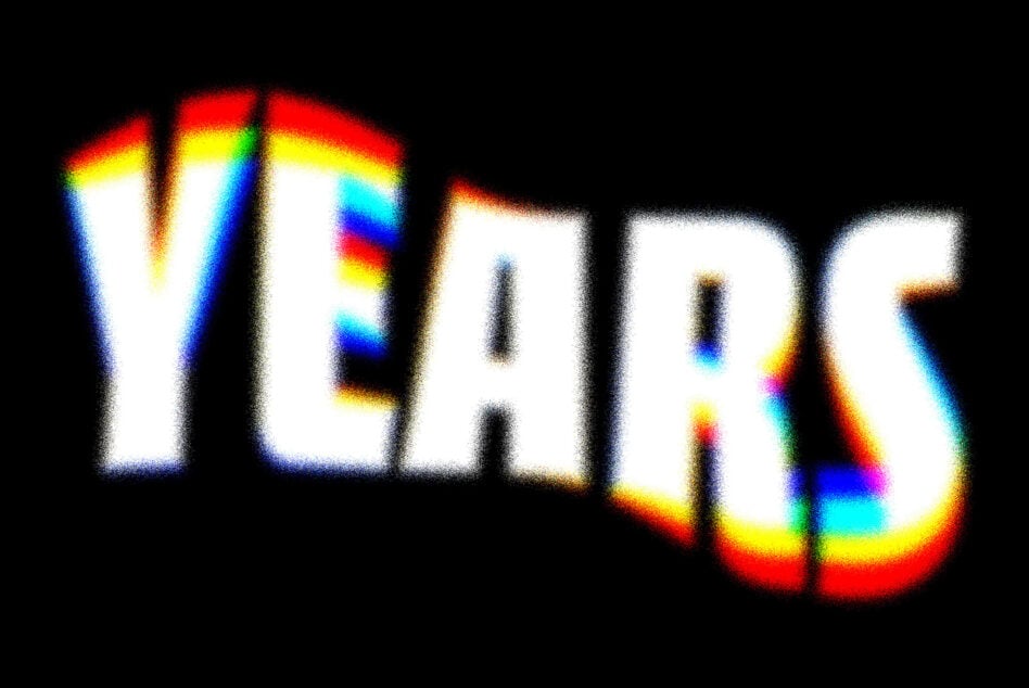 Bold rainbow chromatic blur text effect reading YEAR with 3D styling