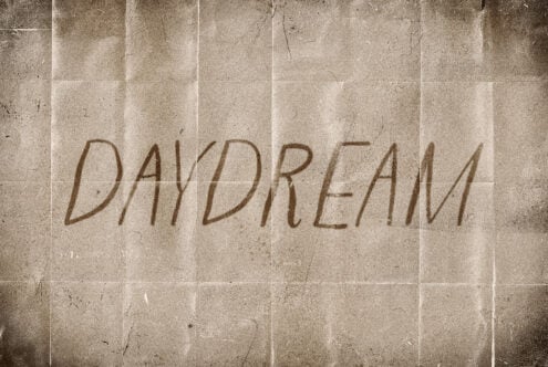 Vintage paper texture with hand-drawn text Daydream in a handwritten style ideal for graphic design templates posters and typography projects.