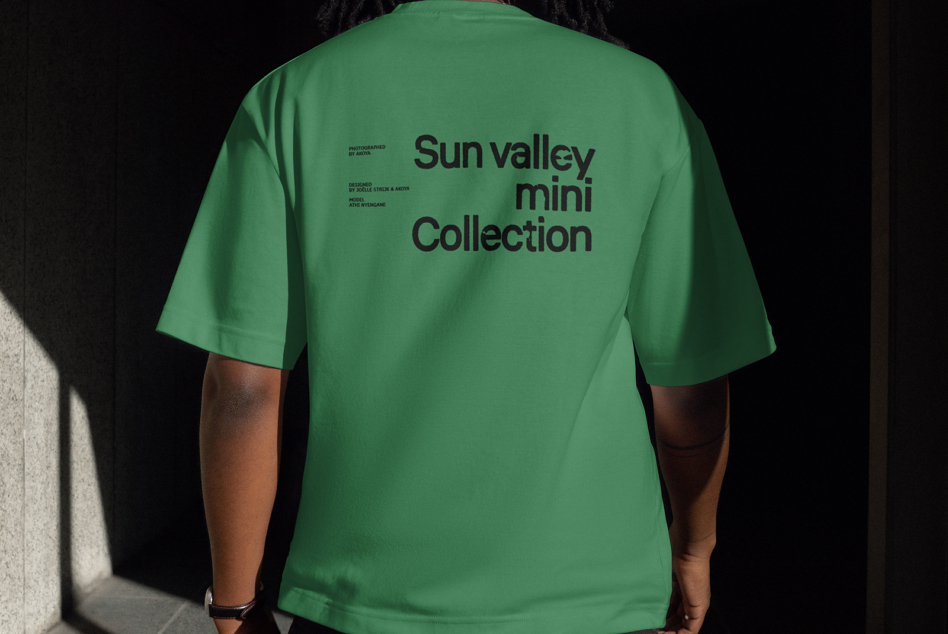 Back view of person wearing green T-shirt with Sun Valley Mini Collection text. Perfect for mockup templates and apparel graphics for designers.