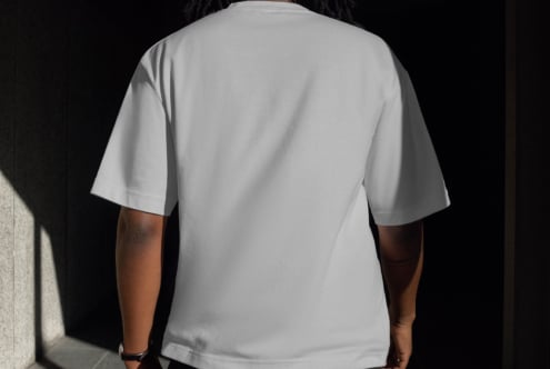 Back view of person wearing plain white T-shirt mockup in natural lighting. Perfect for clothing design presentations and fashion templates.