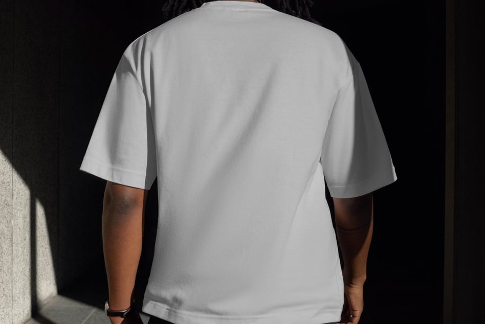 Back view of person wearing plain white T-shirt mockup in natural lighting. Perfect for clothing design presentations and fashion templates.