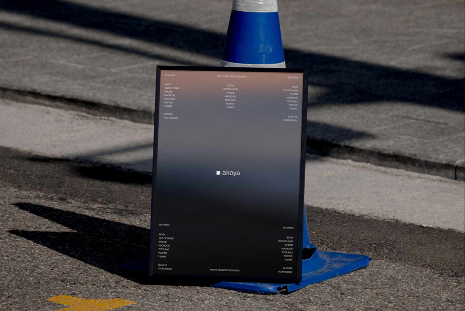 Dark gradient poster with akoya logo leaning on blue cone in outdoor construction zone