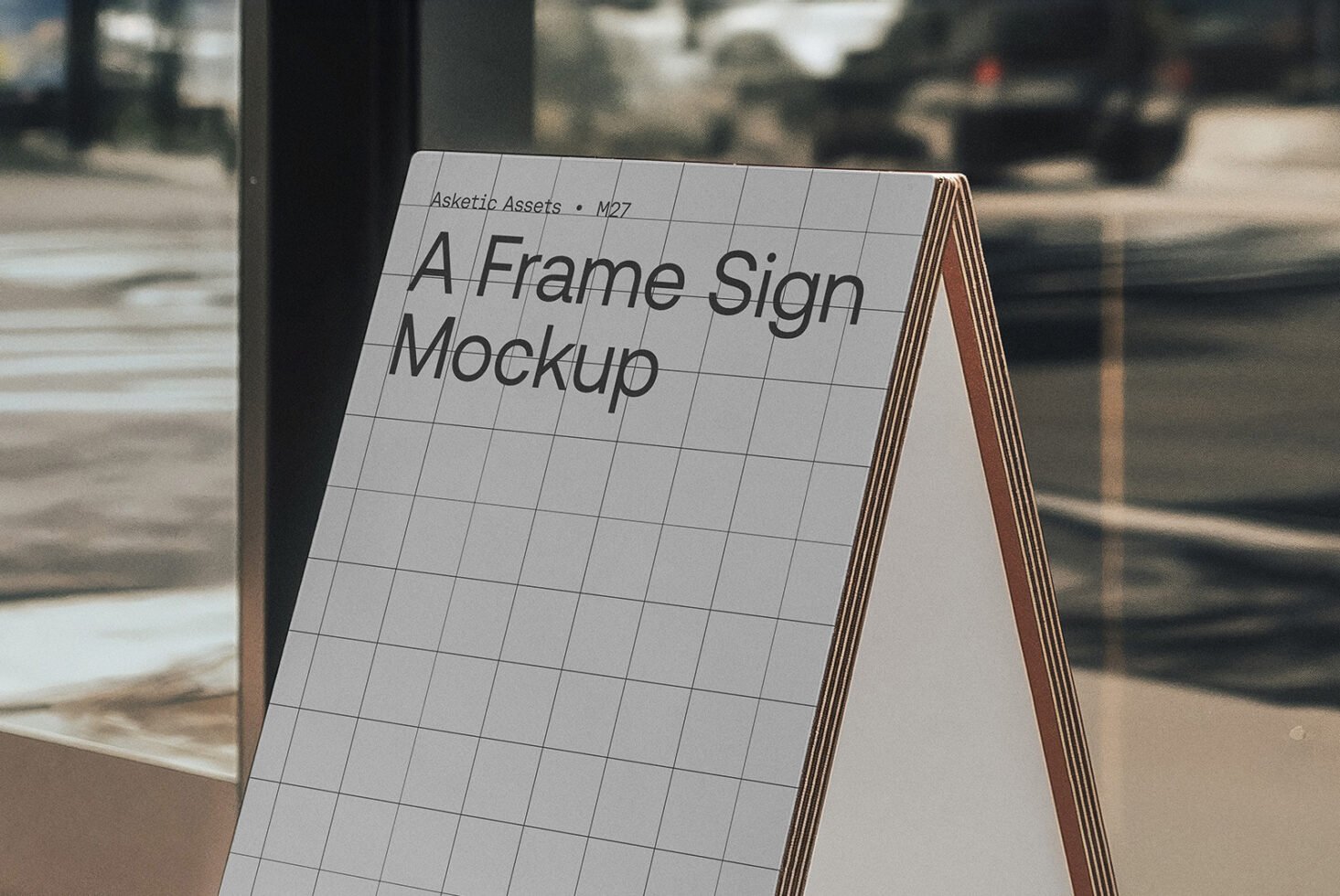 A frame sign mockup standing by a window on a city street background perfect for showcasing graphic design templates and branding ideas