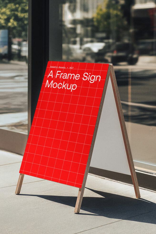 A frame sign mockup with red grid design outside a modern building perfect for showcasing graphics templates or advertising concepts to designers.