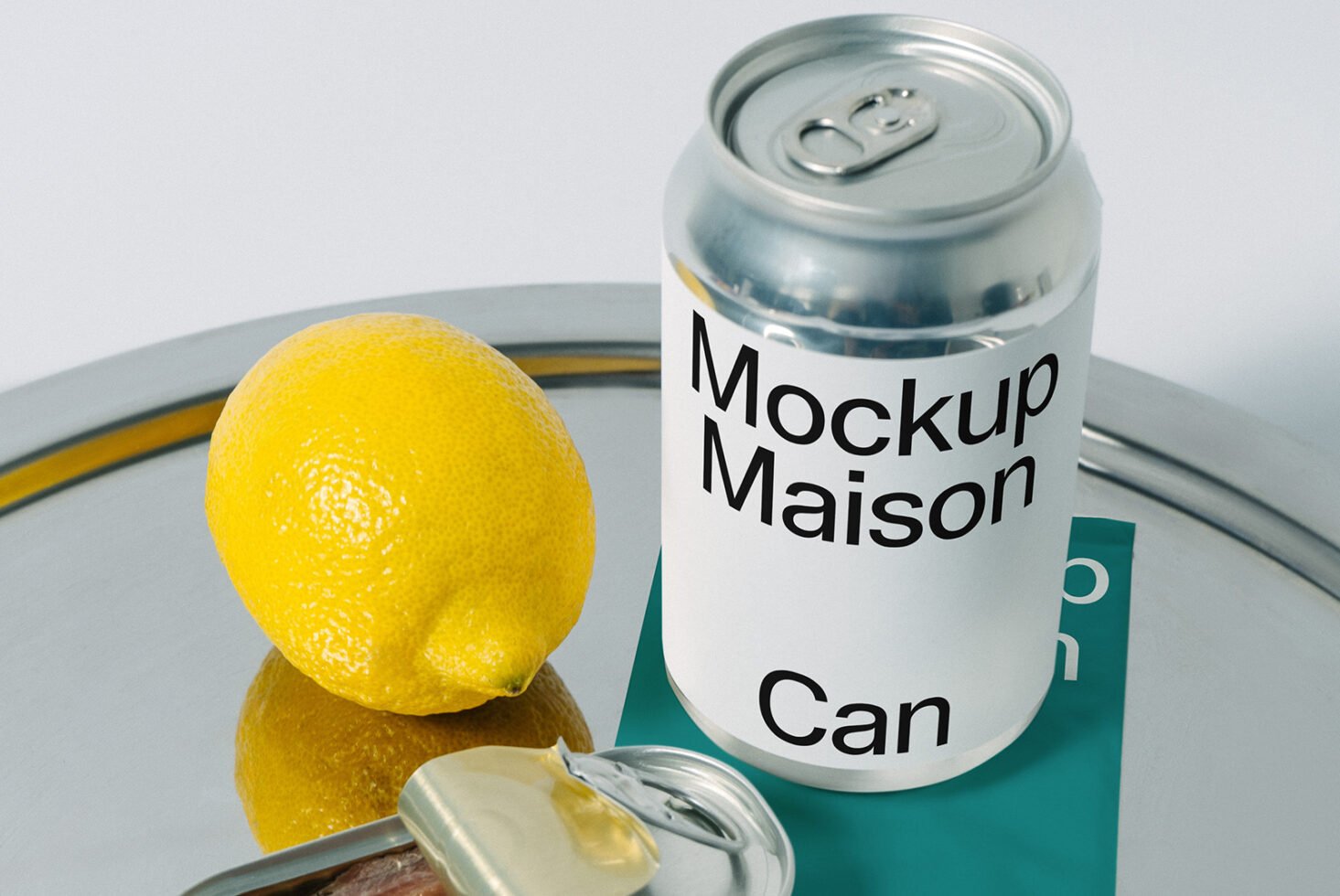 Can mockup image featuring a blank aluminum can, vibrant yellow lemon, ideal for designers creating product packaging graphics and mockups.