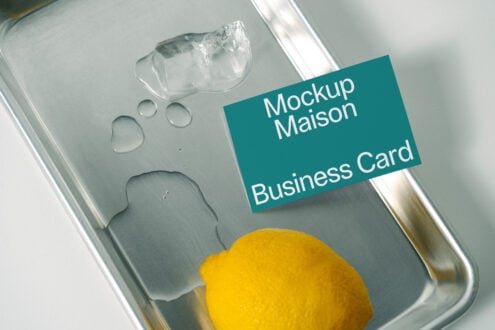 Business card mockup with a teal background on a metal tray featuring ice and a lemon. Ideal for showcasing mockup templates to designers.