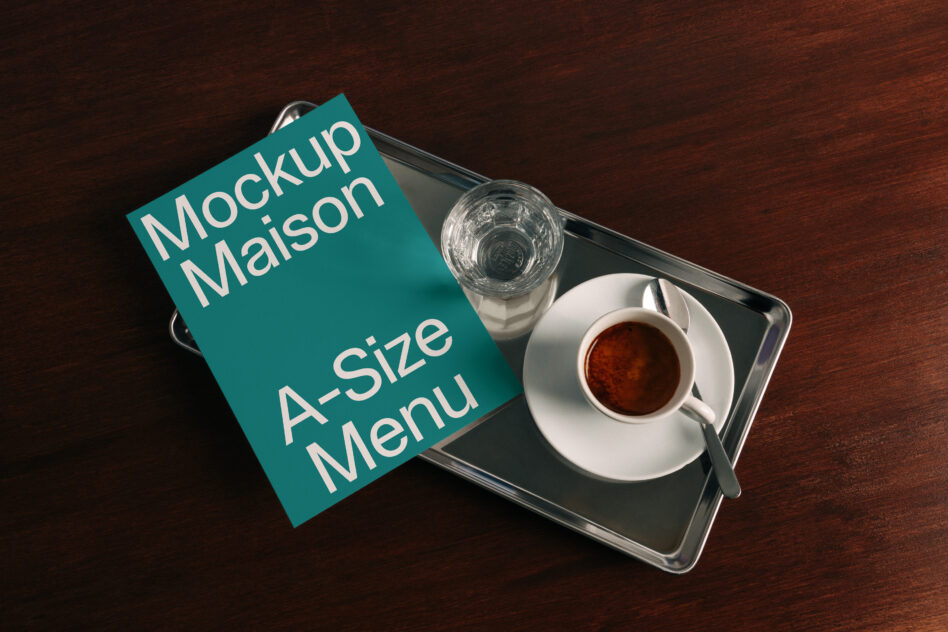 Teal A-size menu card mockup on dark tray with espresso cup water glass wood table