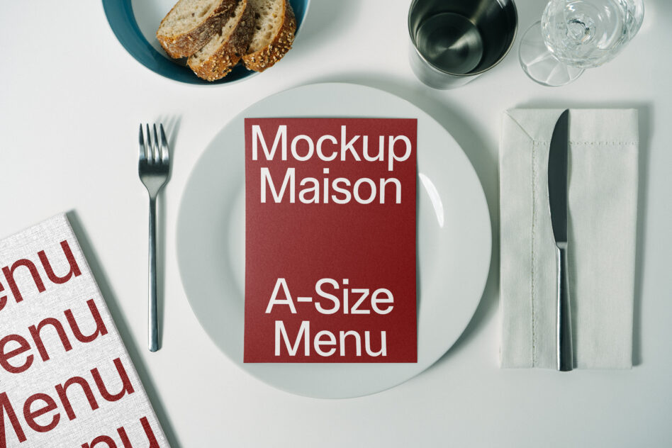 Burgundy A-size menu card centered on white plate with bread, fork, knife