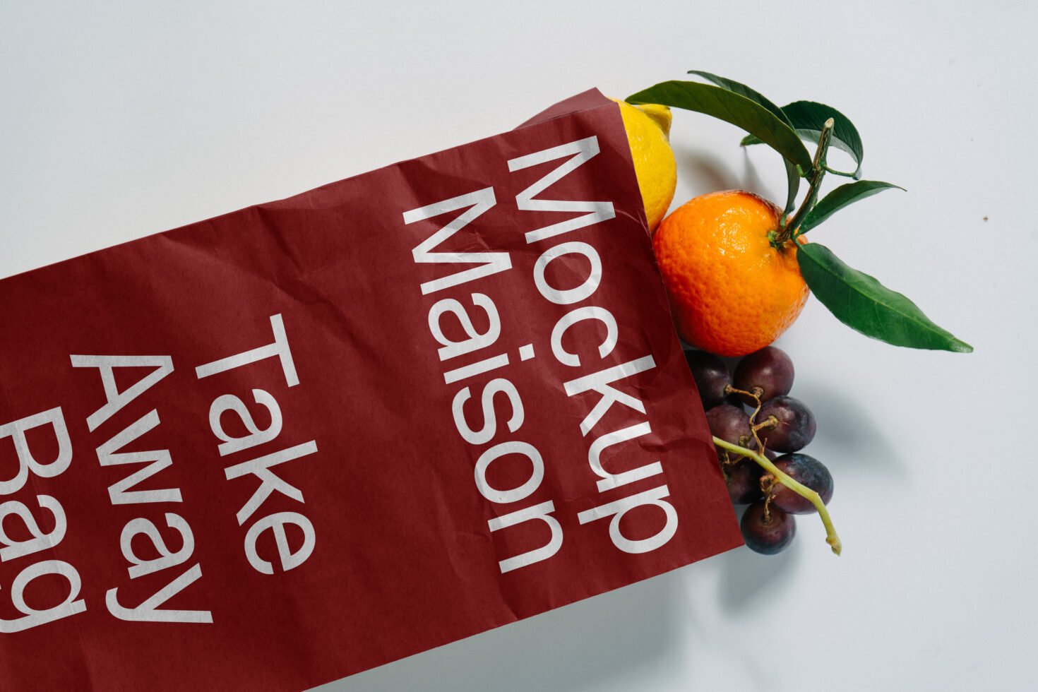 Eco-friendly takeaway bag mockup with fresh oranges and grapes emerging. Ideal for showcasing branding designs and packaging templates for designers.