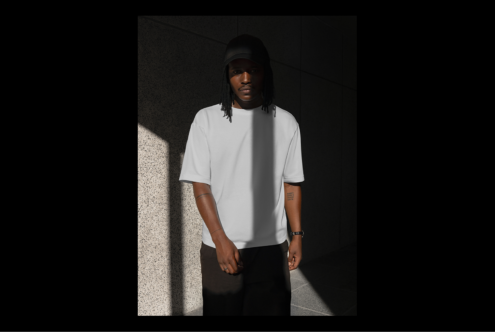 Man in urban setting wearing a plain white t-shirt and cap. Perfect apparel mockup for designers. Modern minimalistic fashion template.