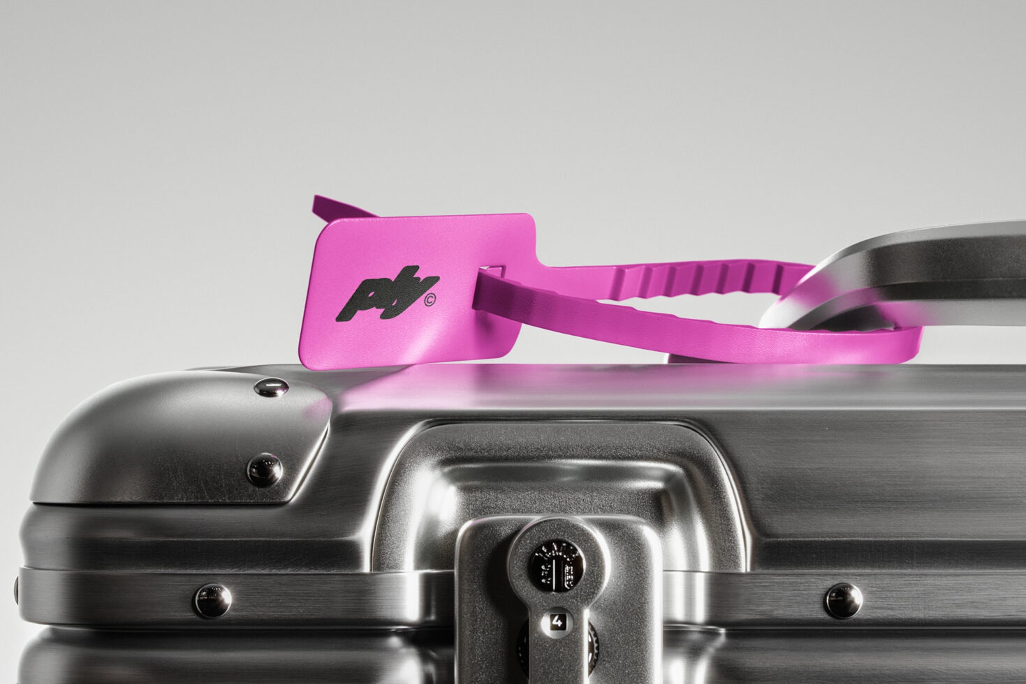 Silver suitcase with purple luggage tag on a gray background. Travel mockup, branding asset, modern minimalist design, high-quality image for designers.