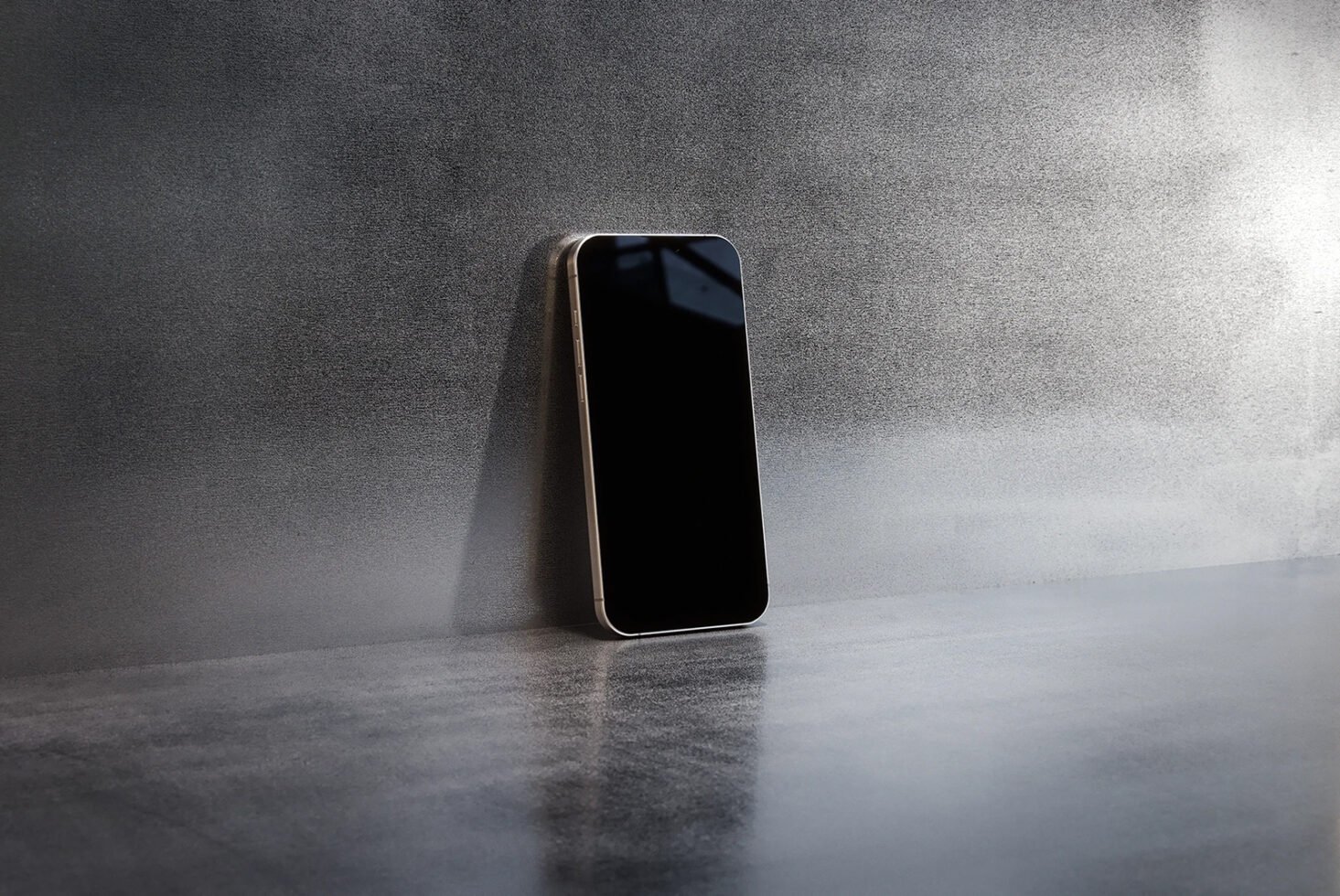 Smartphone mockup on metallic surface leaning against a wall ideal for showcasing mobile app designs tech backgrounds or digital product presentations.