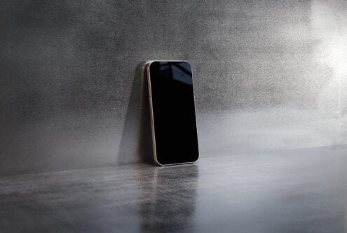 Smartphone mockup on metallic surface leaning against a wall ideal for showcasing mobile app designs tech backgrounds or digital product presentations.