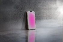 Phone showing soft pink gradient display on concrete floor