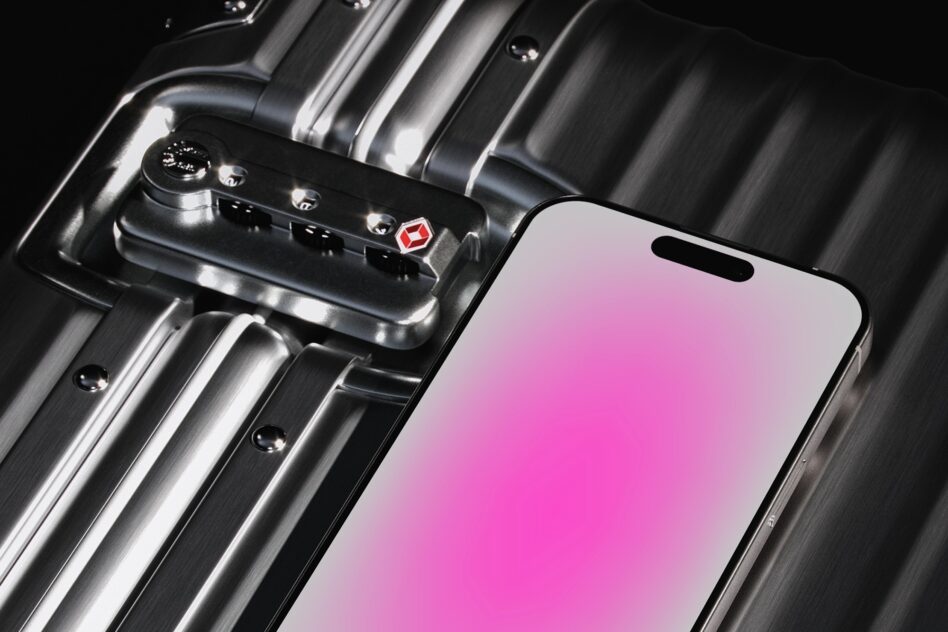 Smartphone on a metallic suitcase with a pink gradient screen ideal for mockup use by designers showcasing modern tech and industrial design elements