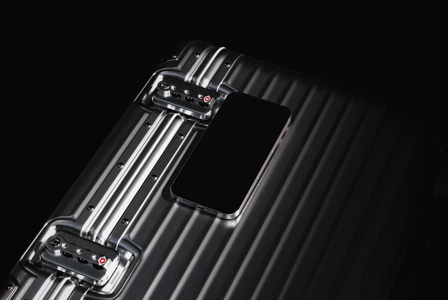Sleek metal suitcase with phone resting on top. High-quality mockup for design projects. Keywords: suitcase mockup design phone showcase graphic resource.