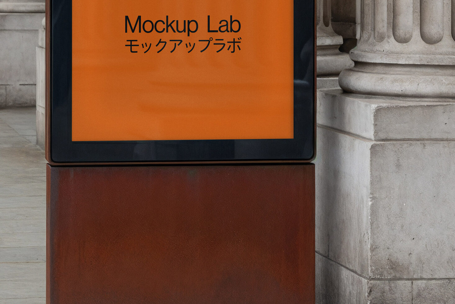 Tablet with orange screen showing Mockup Lab text against stone columns