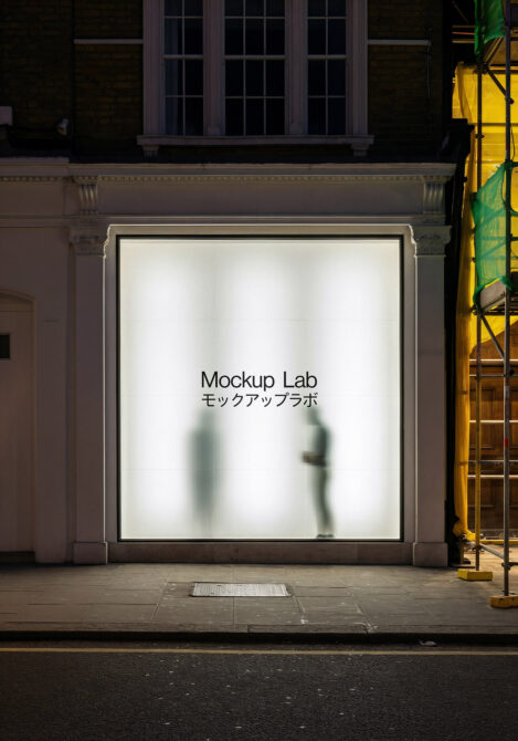Illuminated storefront window showing Mockup Lab text with blurred silhouettes behind glass