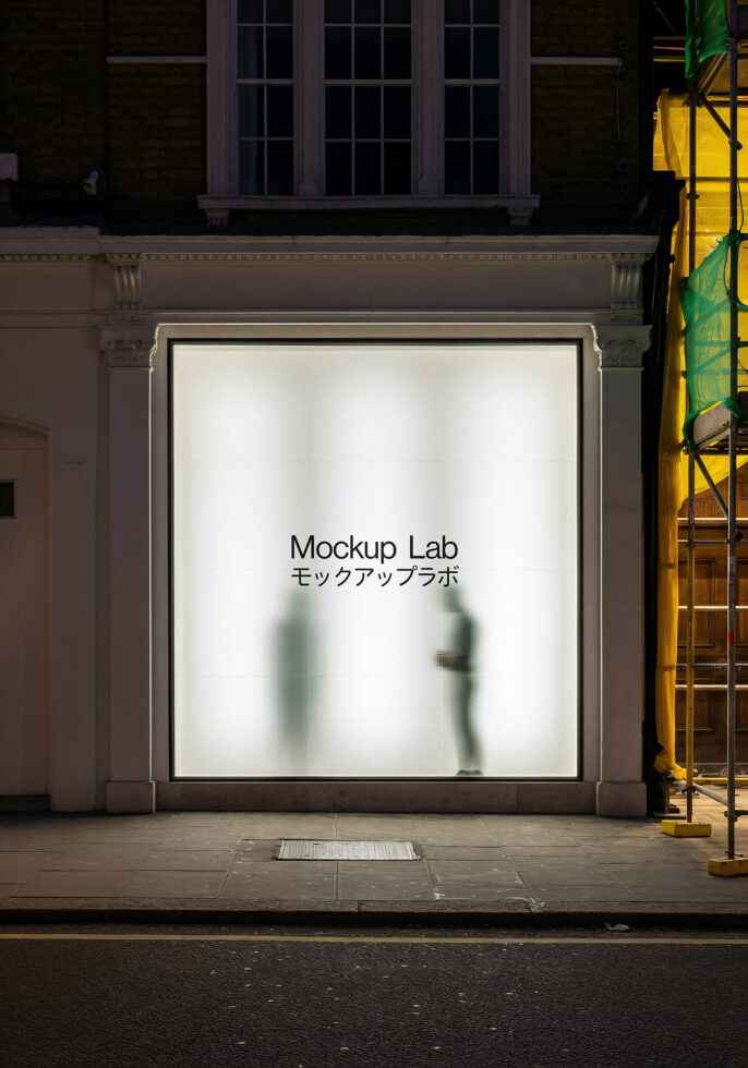 Illuminated storefront window showing Mockup Lab text with blurred silhouettes behind glass
