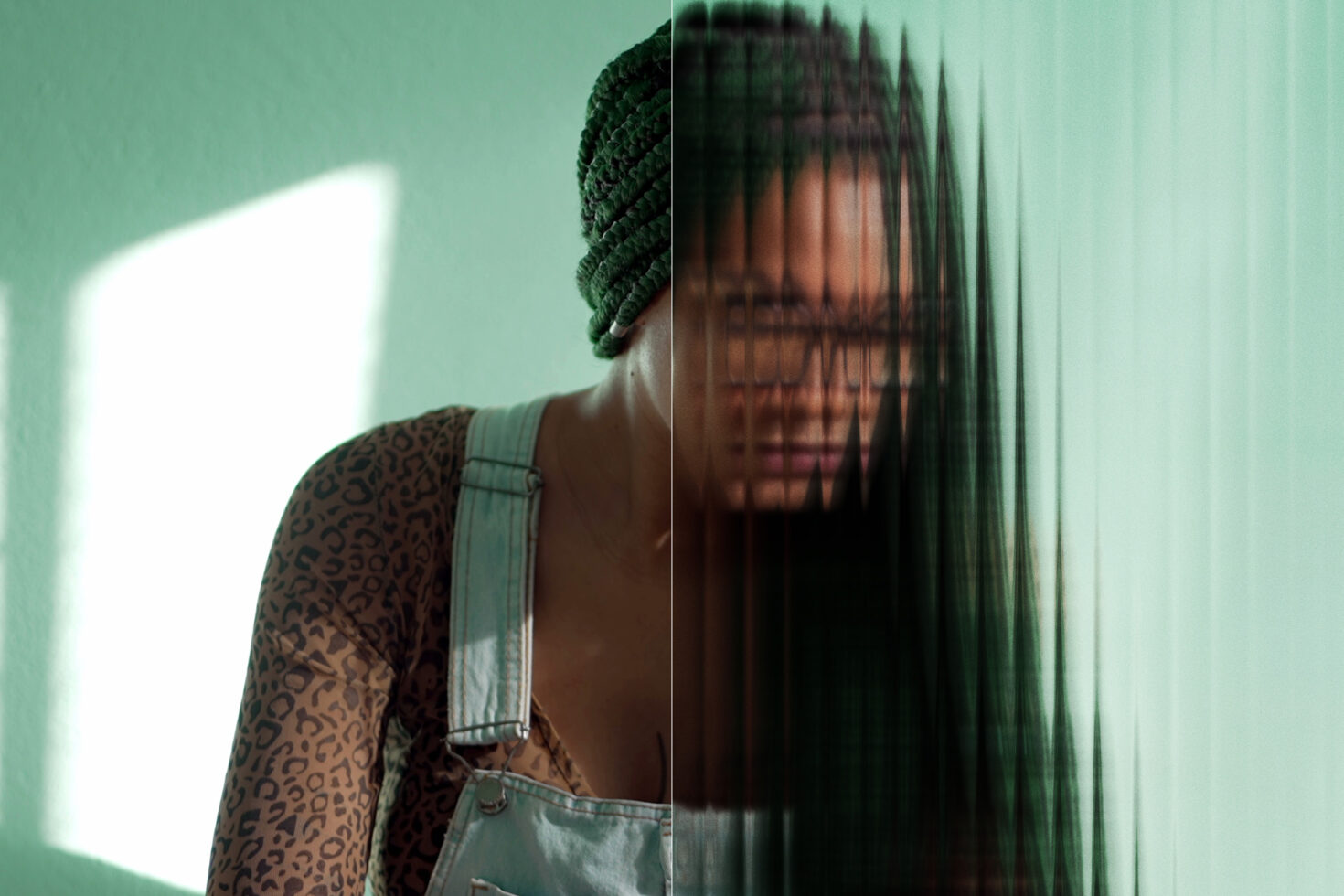 Portrait with mint background split by vertical blur effect creating glitch feel