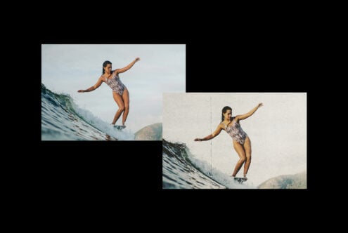 Female surfer balanced on wave in patterned wetsuit with arms extended
