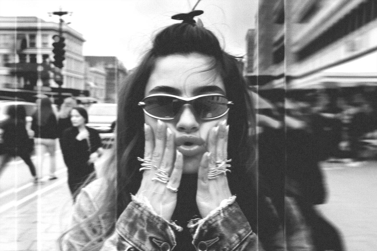 Grainy street scene portrait, person with sunglasses, urban city background VHS look